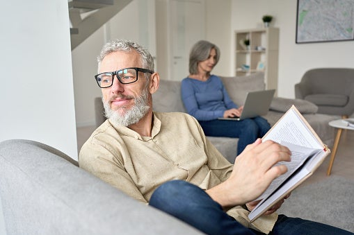 Man looking out window while sitting with wife