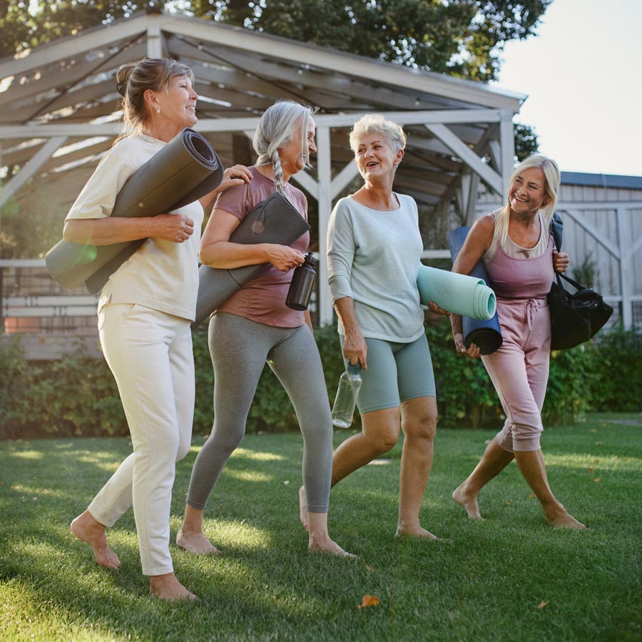 Senior women walking with yoga mats
