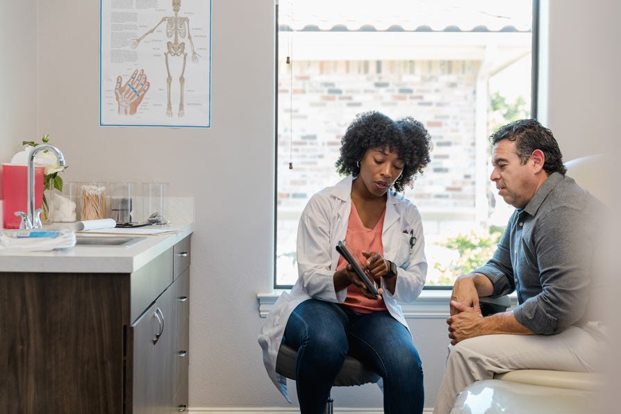 Female doctor speaking with a patient in exam room
