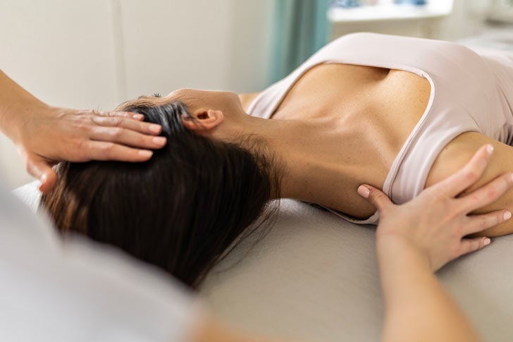 Woman getting neck stretched by chiropractor