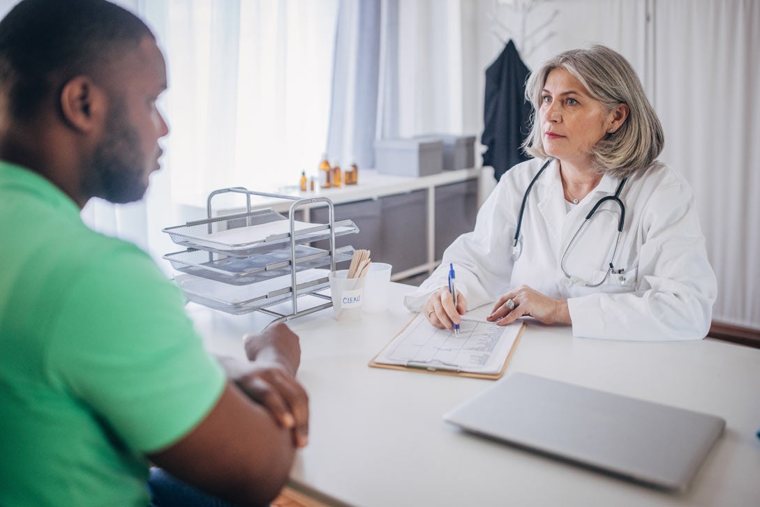 Older femal doctor speaking with a patient in her office