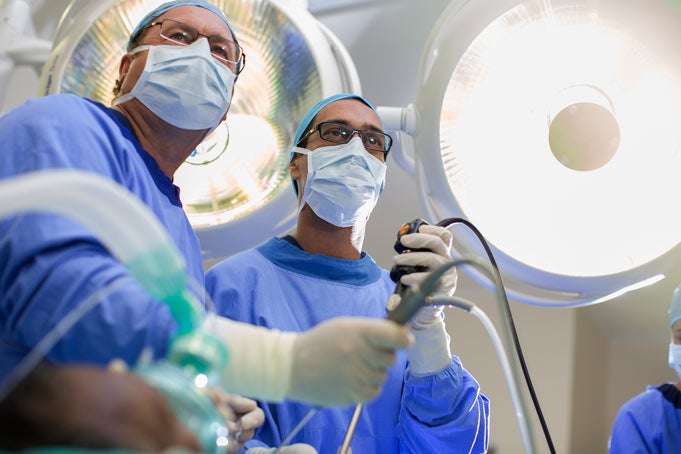 Low angle view of two surgeons holding laparoscopy equipment