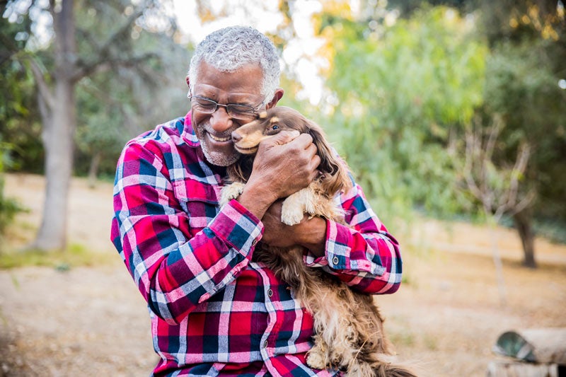 Mature man hugging his dog outside